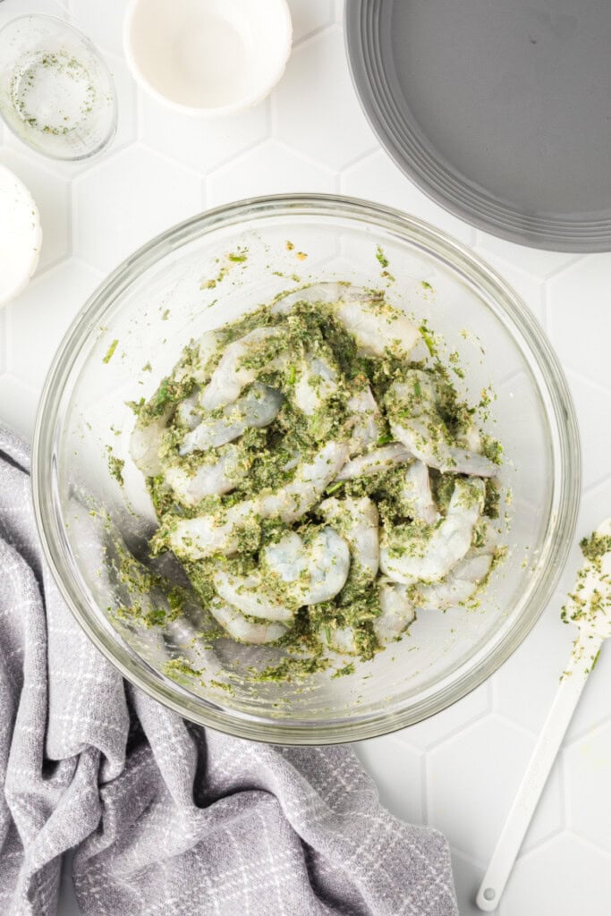Shrimp being stirred into the grilled shrimp marinade.