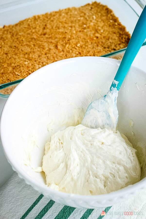 Orange Gelatin Pretzel Salad has a pretzel crust, cream cheese filling, and a fruity gelatin topping. It's a side dish that easily doubles as dessert! cream cheese filling in bowl