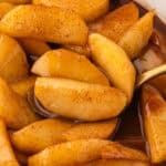 Homemade Southern Fried Apples in buttery cinnamon syrup served in a white bowl.