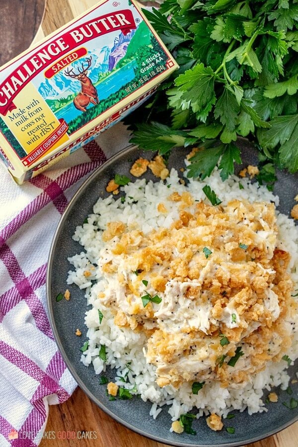 This Poppy Seed Chicken Casserole has a creamy poppy seed sauce filled with shredded chicken and topped with a rich buttery cracker crumb crust. Poppy Seed Chicken Casserole on a plate with a carton of Challenge Butter.