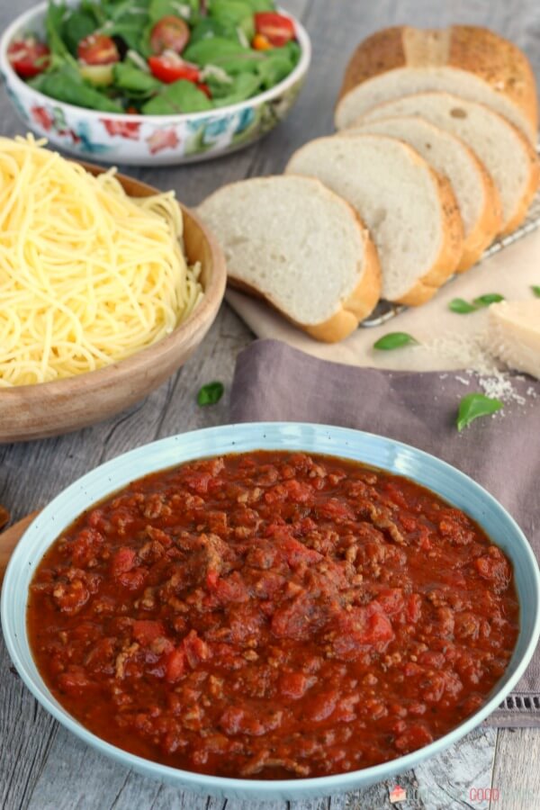 Slow Cooker Spaghetti Sauce that is as easy as throwing everything into your slow cooker. Economical and great for busy weeknights. Slow Cooker Spaghetti Sauce and pasta with bread slices and a green salad.
