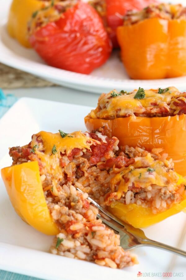 Stuffed Peppers Recipe using ground beef or sausage in the Crockpot is an easy weeknight meal. Best ever Slow Cooker Stuffed Pepper Recipe. Slow Cooker Stuffed Peppers on a plate with a fork.