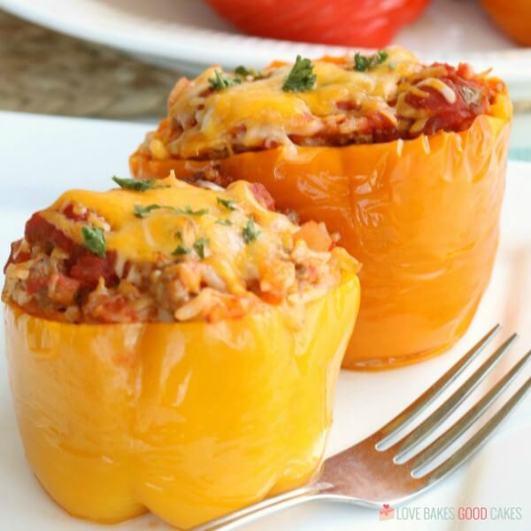 Stuffed Peppers Recipe using ground beef or sausage in the Crockpot is an easy weeknight meal. Best ever Slow Cooker Stuffed Pepper Recipe. Slow Cooker Stuffed Peppers on a plate close up with a fork.