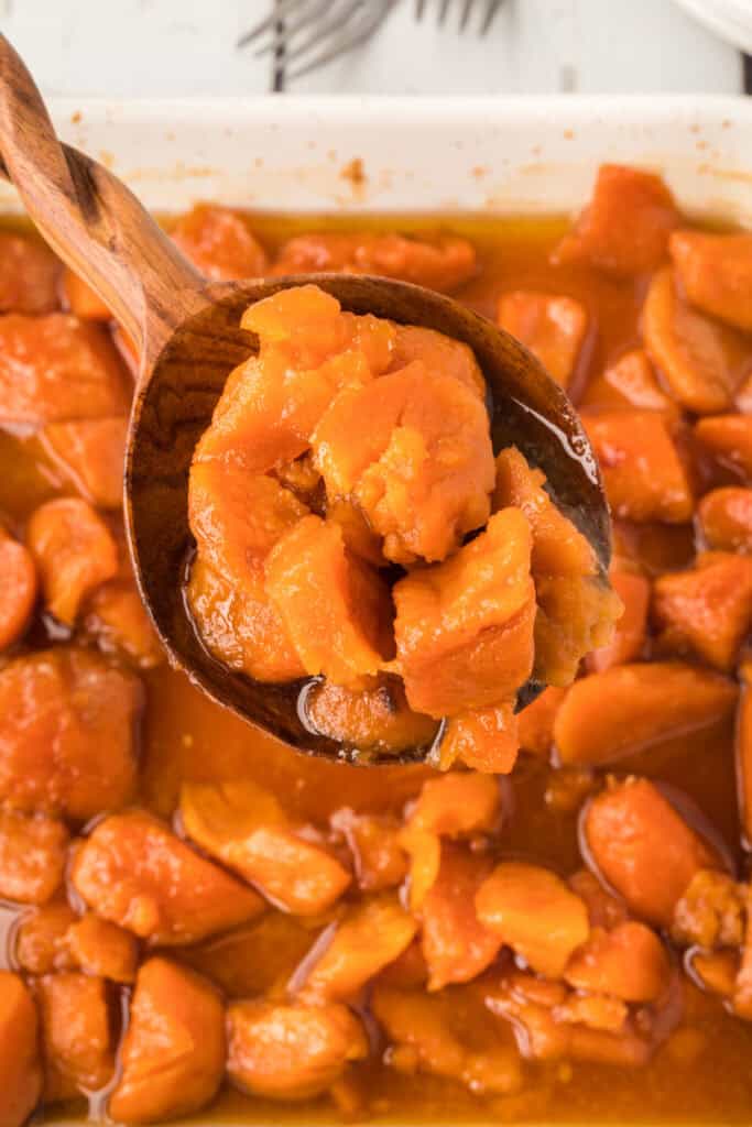 Spoonful of tender candied yams coated in buttery brown sugar sauce