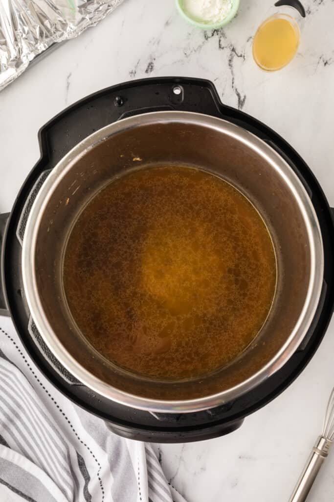 Turkey drippings simmering in the Instant Pot set to sauté mode, ready to be thickened for gravy.