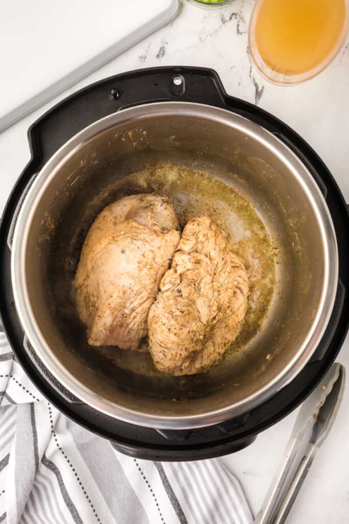 Seared turkey breast in Instant Pot showing golden brown color from sautéing.