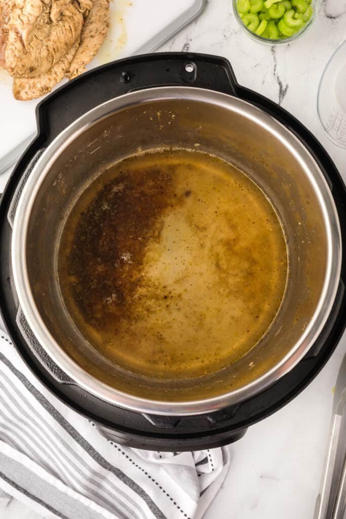 Inside view of Instant Pot showing brown cooking juices and drippings for making gravy.