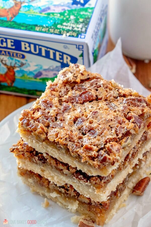 Skip the pie and make these Pecan Pie Bars! Shortbread topped with a gooey filling and crunchy pecans in an easy-to-eat with your hands' bar! Pecan Pie Bars close up with a package of Challenge Butter