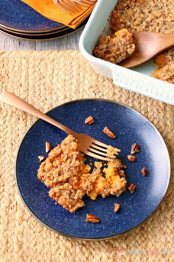 Making this easy sweet potato casserole recipe for the holidays is perfect - it is made with pecans and it is so delicious! Sweet Potato Casserole on a blue plate with a fork.
