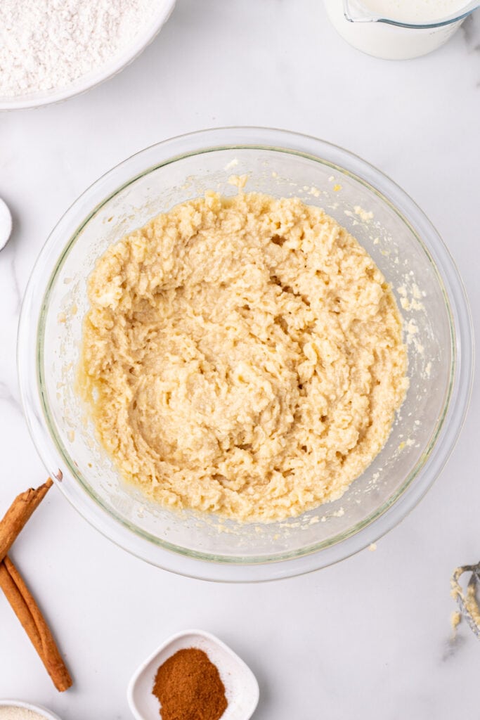 creamed butter and sugar mixture in a glass bowl showing a fluffy, pale yellow texture