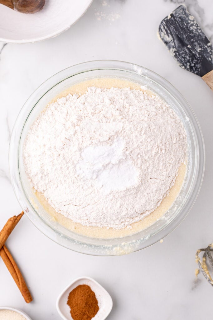 flour added on top of the wet ingredients in a glass mixing bowl before folding together