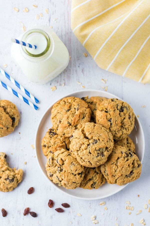 Easy recipe for the ultimate Oatmeal Raisin Cookies - slightly crunchy on the outside with a perfectly soft, heavenly chewy texture when you bite into them. cookies on plate with milk