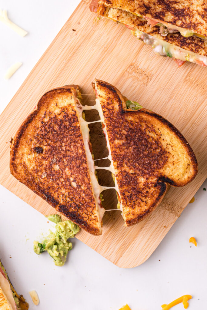 sandwich cut in half with small cheese pull