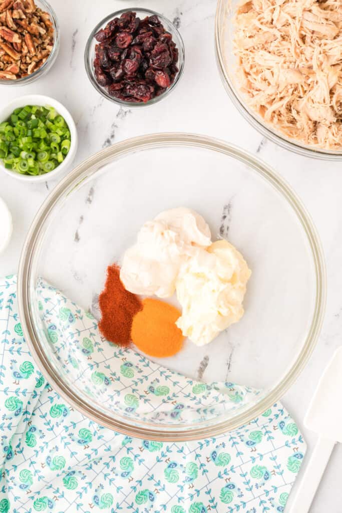 mayonnaise, Miracle Whip, and seasonings in a glass bowl for chicken salad with Miracle Whip