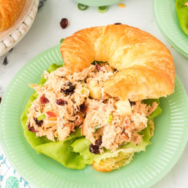 chicken salad with Miracle Whip served on a croissant with lettuce on a green plate