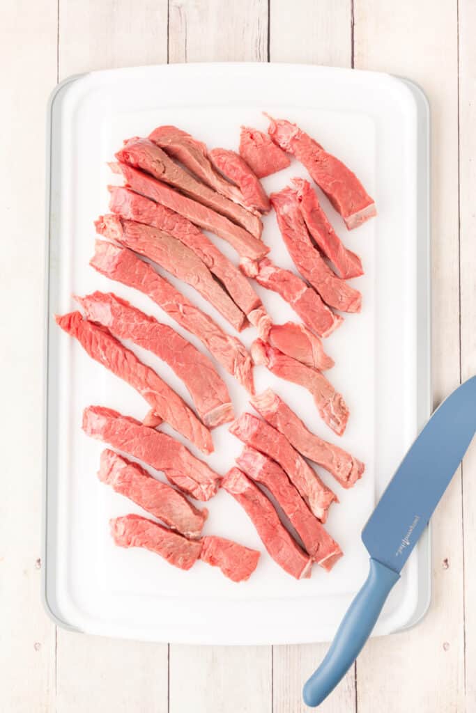Place the steak between two pieces of plastic wrap and pound to ¼-inch thickness. Cut the steak into strips.