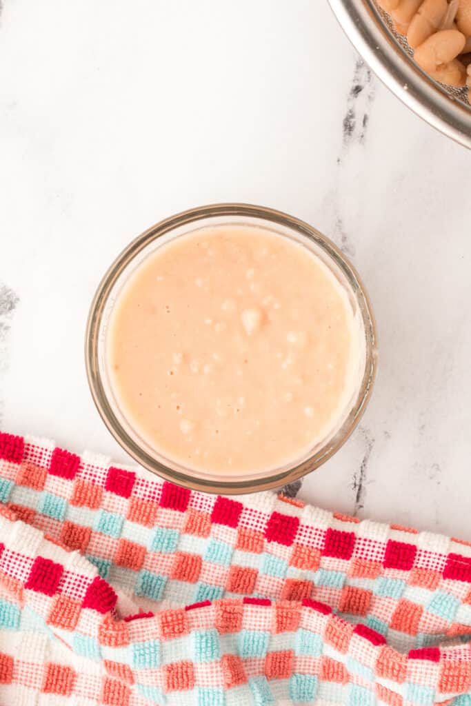 Blended white beans and broth mixture in a small bowl, ready to be added for creaminess.