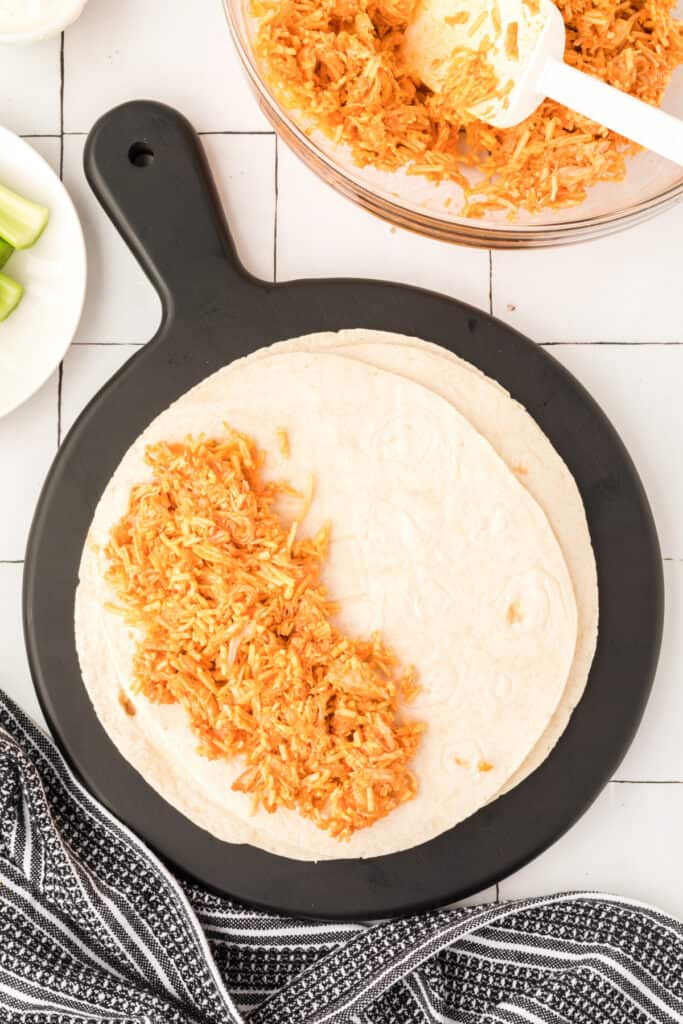 Buffalo chicken filling added to flour tortillas for Buffalo Chicken Quesadillas