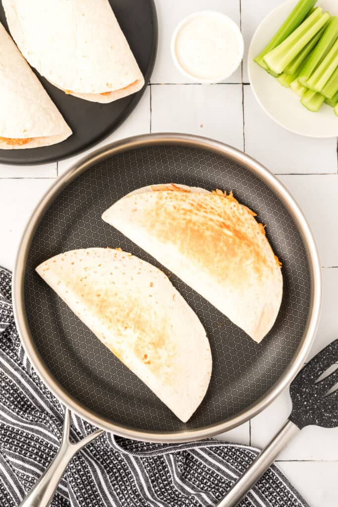 Buffalo Chicken Quesadillas cooking in a skillet until golden brown