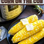 instant pot cooked corn on a plate with butter pats and pressure cooker in background