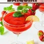 Strawberry Daiquiri in glass garnished with lime, strawberries, and mint