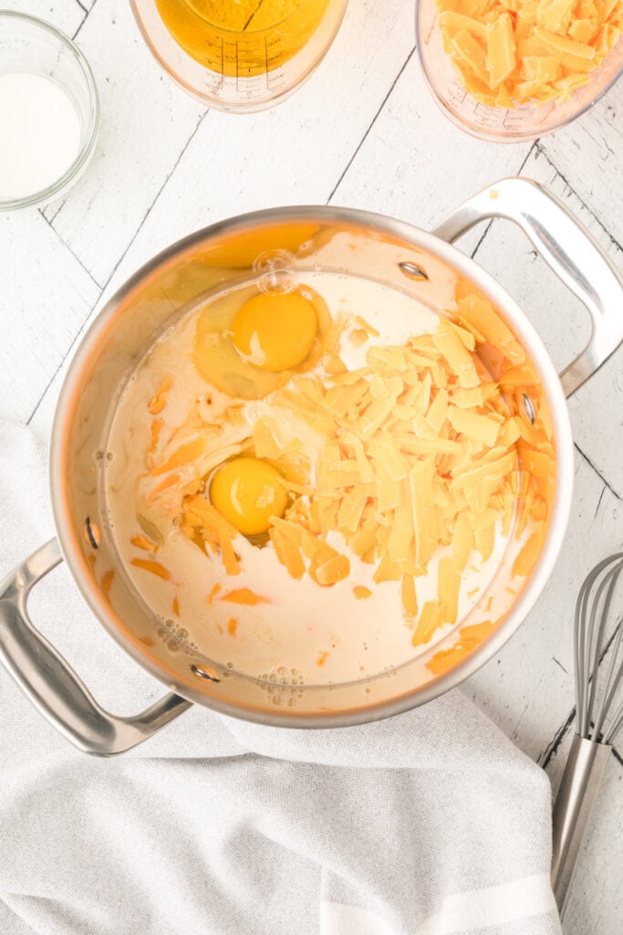 saucepan with milk, eggs, and shredded cheese added before cooking