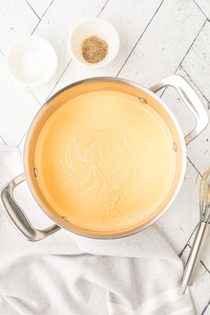 saucepan with melted cheese mixture turning smooth and creamy