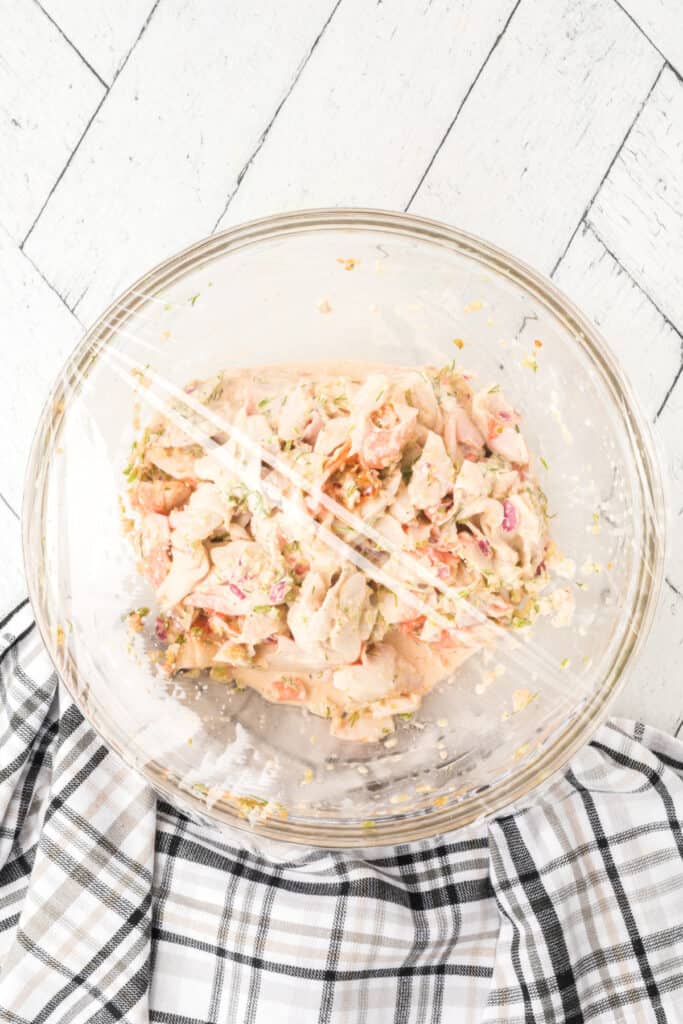 Homemade Deli-Style Crab Salad covered with plastic wrap and refrigerated to let the flavors develop.
