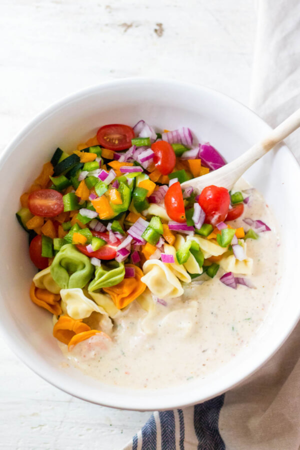 tortellini pasta salad ingredients in bowl before being mixed