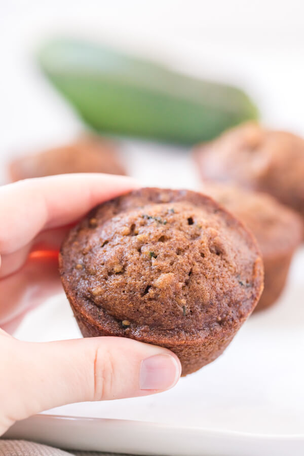 left hand holding zucchini muffin