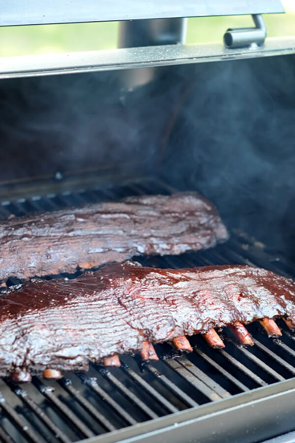 Two racks of ribs being smoked on the grill