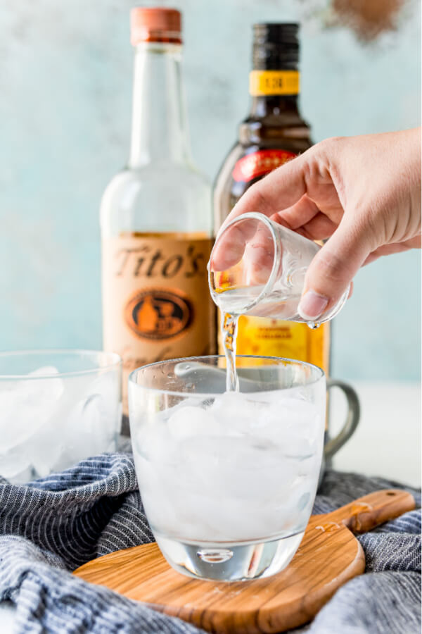 pouring vodka into glass over ice