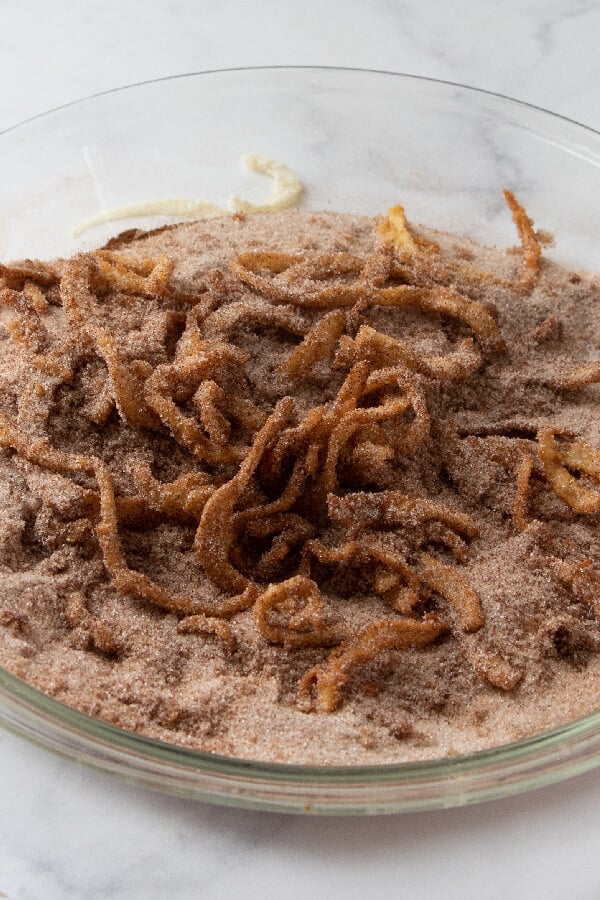 coating the apples in cinnamon-sugar