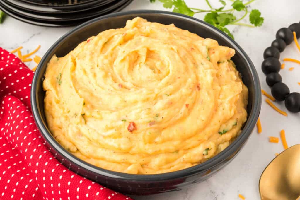Side view of Chipotle Cheddar Mashed Potatoes in a black bowl