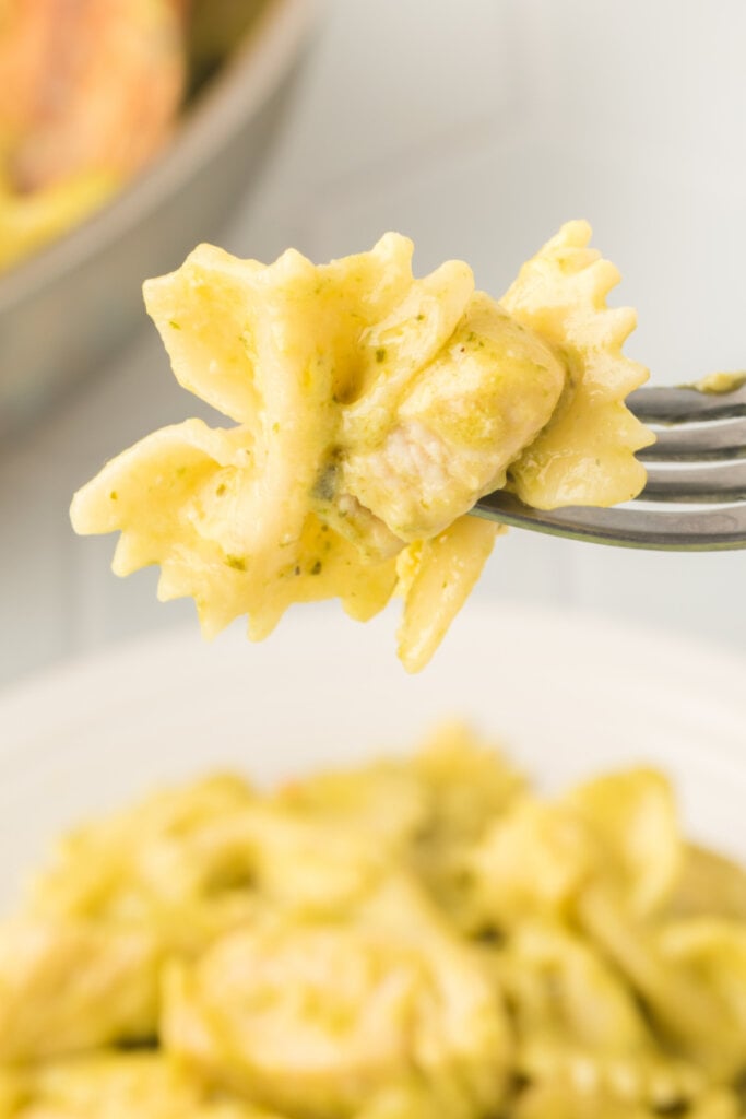 bite of creamy chicken pesto pasta on a fork