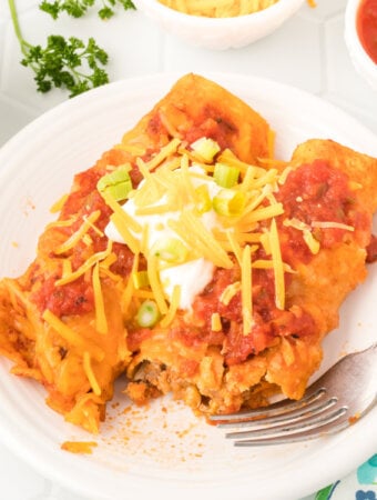 two ground beef enchiladas on a serving plate