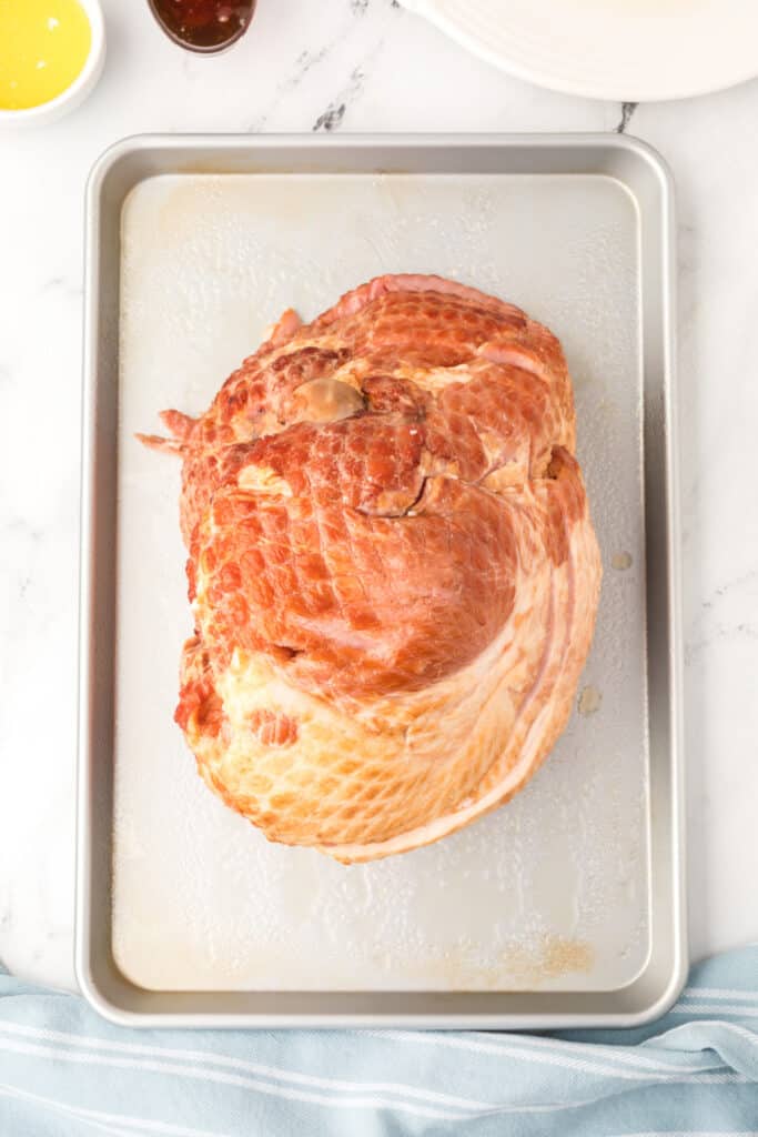 Preheat the oven to 350°F. Coat an oven roasting pan or 9x13-inch baking dish with cooking spray. Place the ham in the pan, cut side down.