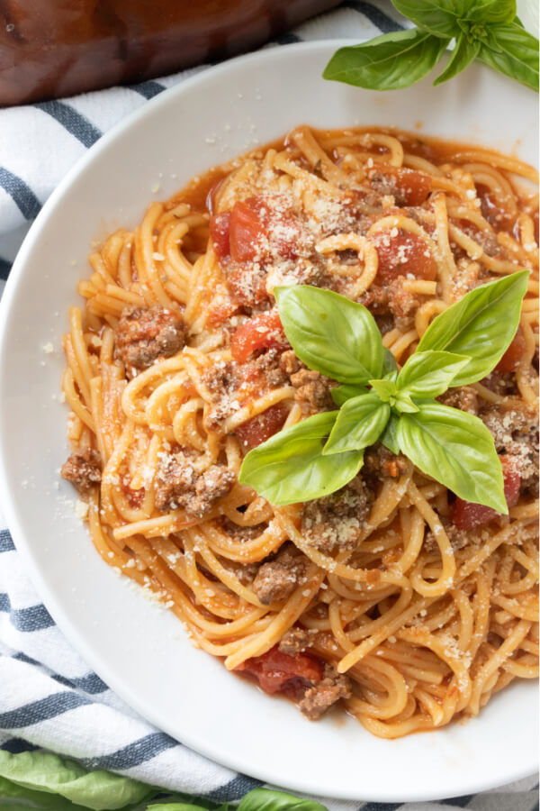 finished instant pot spaghetti in bowl garnished with basil