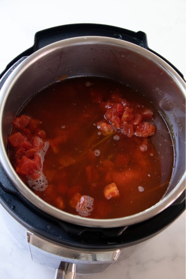 sauce, broth, tomatoes, and wine added to the pot