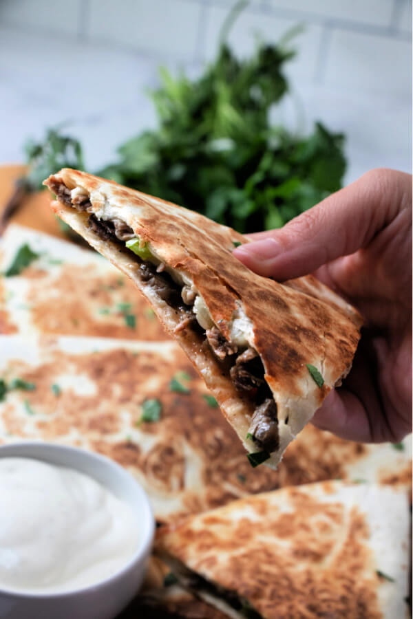 hand holding quesadilla wedge