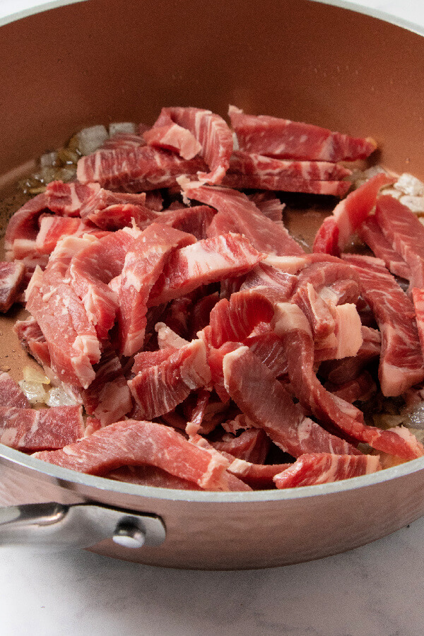 adding the beef strips to the pan