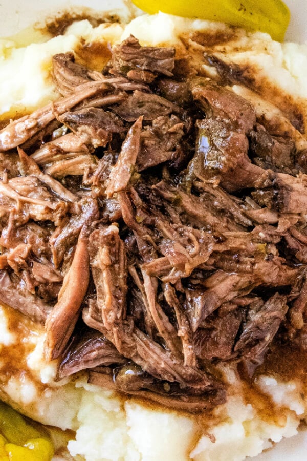 closeup of shredded meat over mashed potatoes