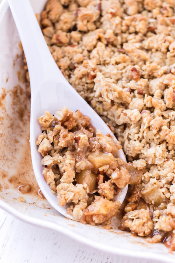 spoon of apple crumble resting in dish