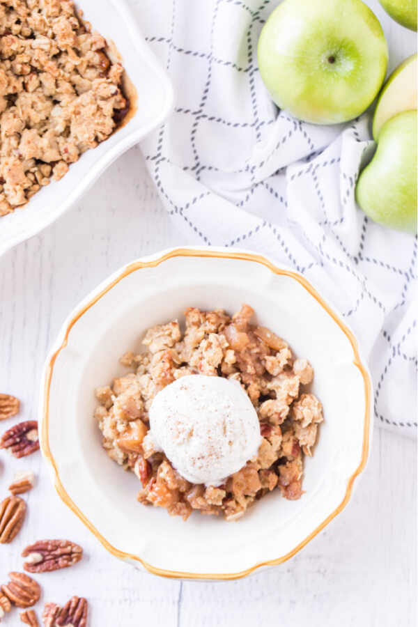 apple crumble in bowl with scoop of ice cream