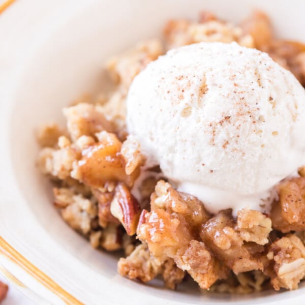 apple crumble in bowl with scoop of ice cream