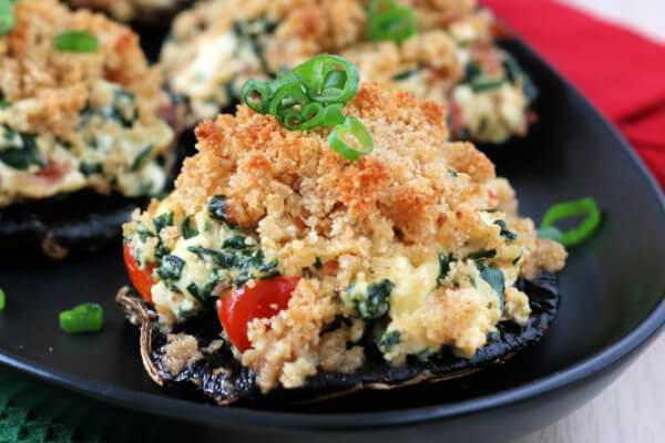 closeup of stuffed mushroom on black plate