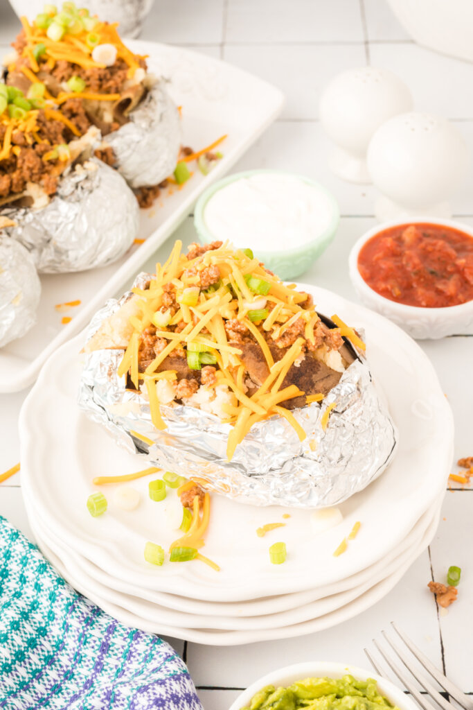 looking down onto a potato filled with taco toppings on plate