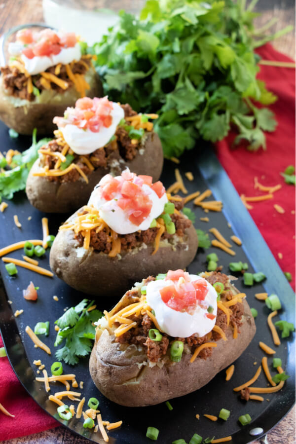 four potato tacos on black plate