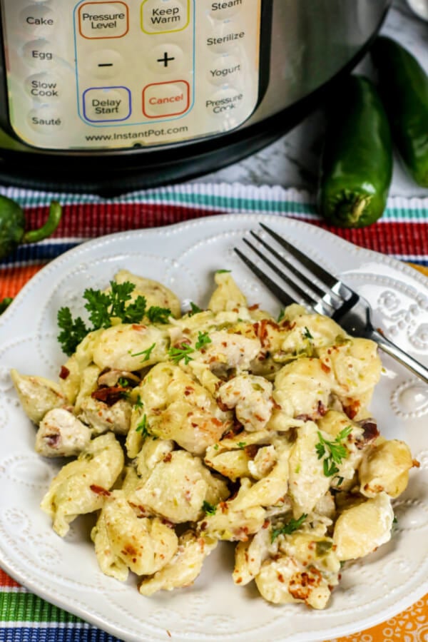 Instant Pot Chicken Jalapeno Popper Pasta on white plate with instant pot in background