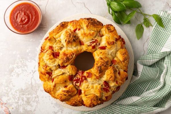 pull apart bread on plate with a bowl of pizza sauce off to the side